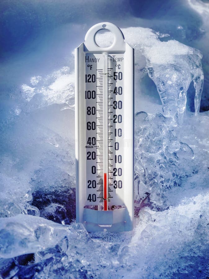 Thermometer showing below freezing temperatures surrounded by ice and snow