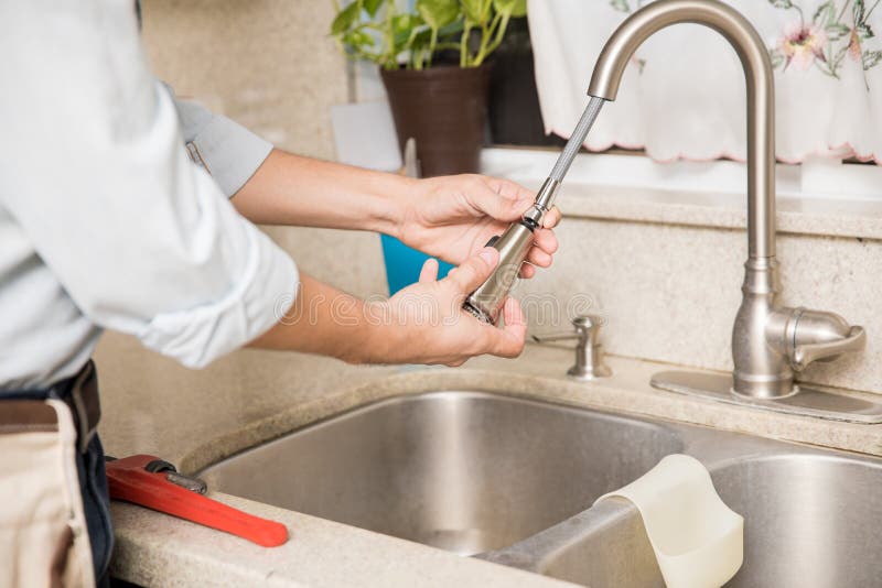 Handyman fixing leaky faucet