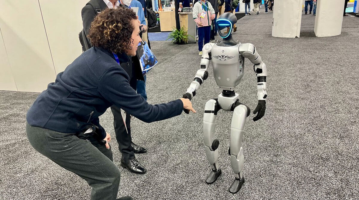 Humanoid robot shaking hands with person at CES 2025 technology expo