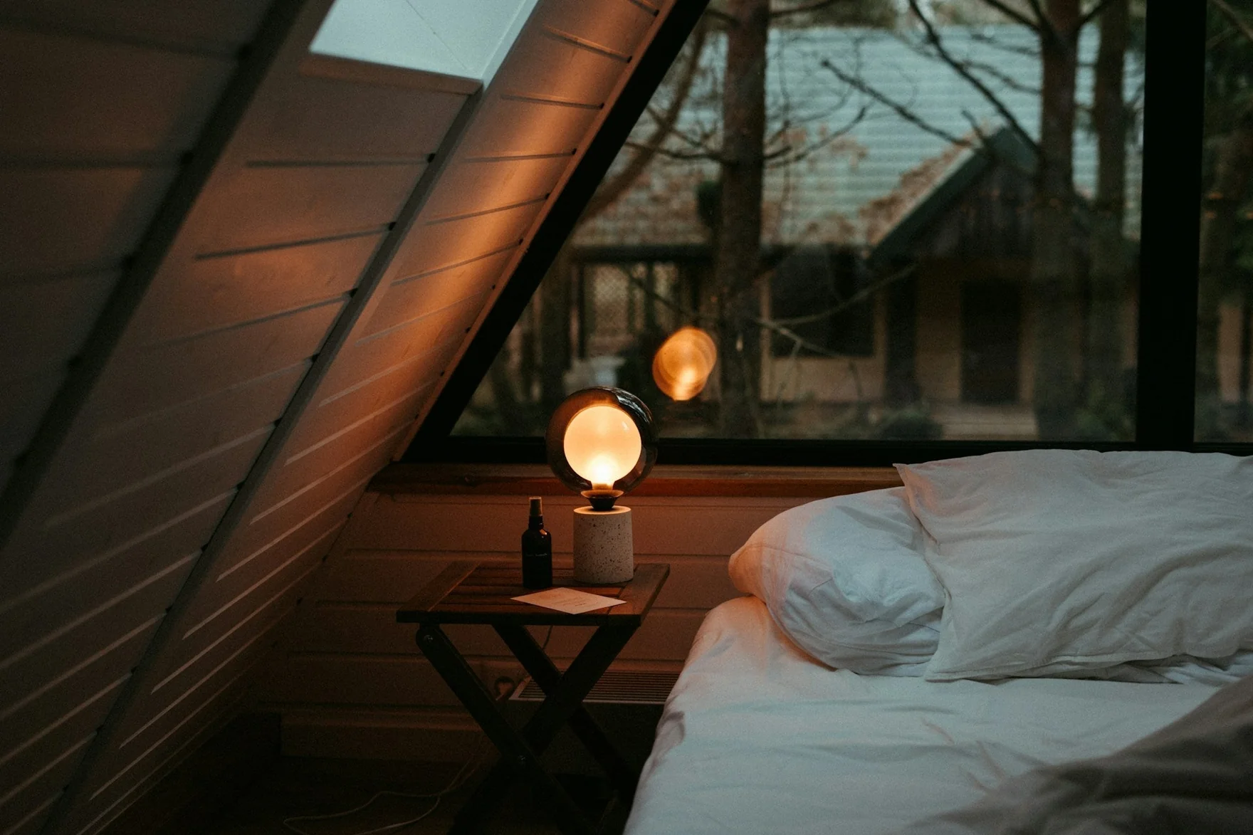 Cozy bedroom with warm lamp light and comfortable bed for evening wind down