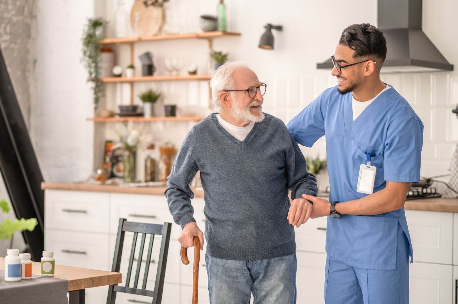 Professional caregiver helping senior gentleman at home