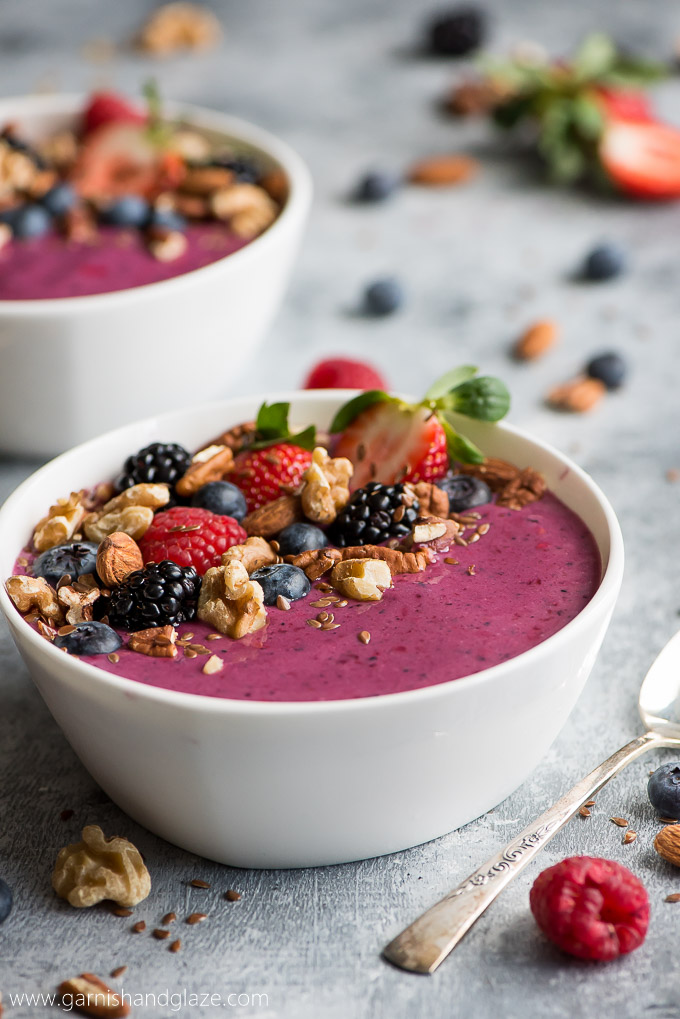 Colorful berry and nut smoothie bowl topped with fresh fruit