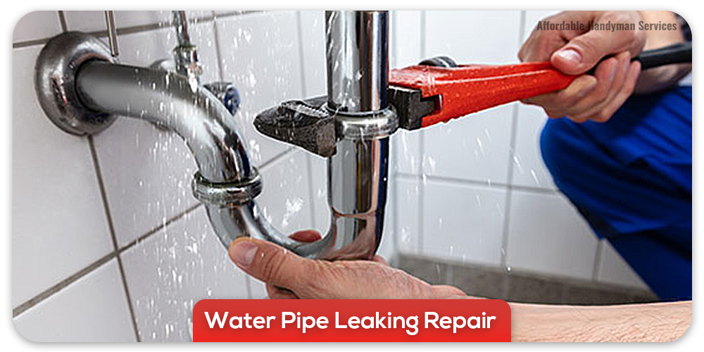 Plumber fixing leaking pipe with wrench
