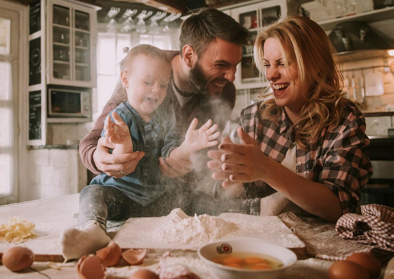 Family using natural remedies and cooking together at home Happy family cooking together in a warm cozy kitchen