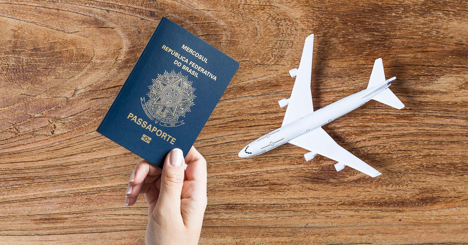 Passaporte brasileiro ao lado de miniatura de avião, simbolizando a emigração de jovens brasileiros para o exterior