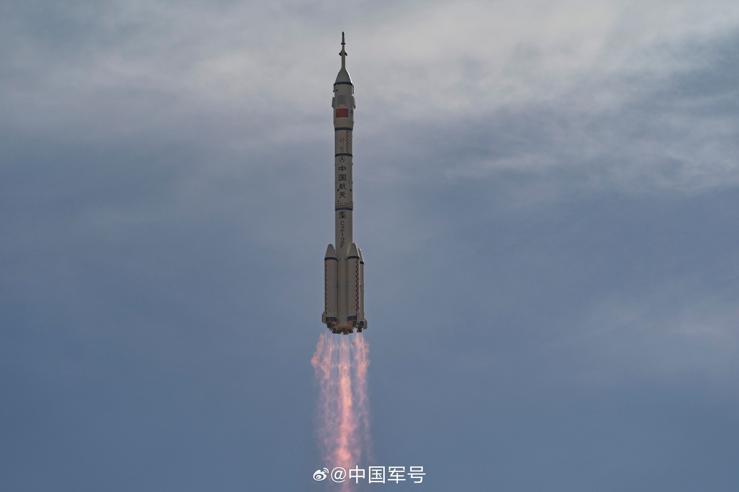 Foguete Longa Marcha 2F da China decolando do Centro de Lançamento de Jiuquan com chamas visíveis na base