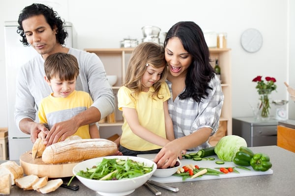 Family cooking healthy weeknight dinner together at home Happy family cooking a healthy dinner together in a bright modern kitchen