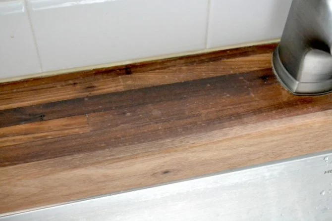 Rancid coconut oil damage on wooden cutting board showing yellow sticky residue and dark stains after 30 days