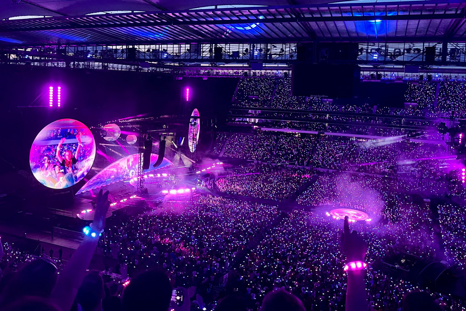 Coldplay band members performing on stage with atmospheric lighting