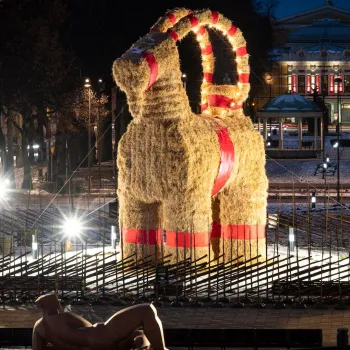 The illuminated Gävle Goat straw sculpture standing tall at Rådhusesplanaden square during blue hour twilight in winter Sweden